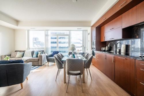 a kitchen and living room with a table and chairs at Cozy 1 BR & Den Condo in North York Free Parking in Toronto