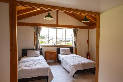 Dos camas en una habitación con ventana. en Sae Garden KAMOGAWA - Vacation STAY 59199v, en Kamogawa