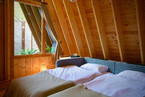 a room with three beds in a room with a window at Angler's Base SHIMOKITAYAMA Fishing Lodge - Vacation STAY 73805v in Kami-ikehara