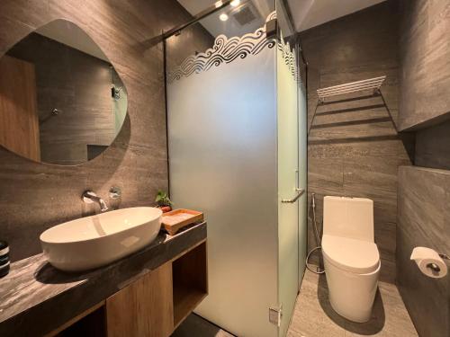 a bathroom with a sink and a toilet and a mirror at Villa Klub Bunga - by The Batu Hotel Batu Malang in Batu