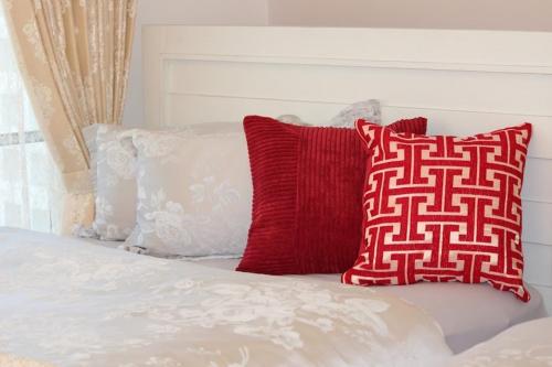 a bed with red and white pillows on it at Red Dragon - Vacation STAY 15430 in Urasoe