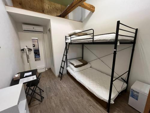 a room with two bunk beds and a ladder at K-style Nishijin backpackers - Vacation STAY 17741 in Kyoto
