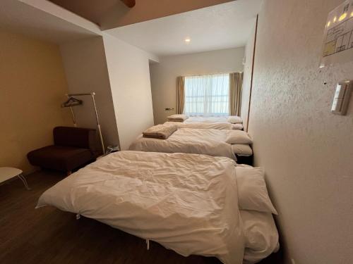 a row of beds in a room with a window at K-style Nishijin backpackers - Vacation STAY 15407 in Kyoto