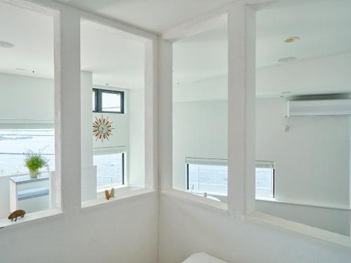 a room with white windows and the ocean at &SUN Terrace house - Vacation STAY 67119v in Yokosuka