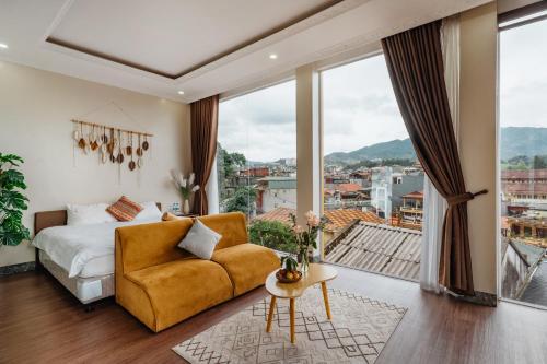 a bedroom with a yellow couch and a large window at Love House Homestay SAPA in Sa Pa