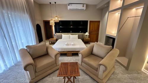 a bedroom with a bed and two chairs at Aryaf hostel in Nizwa
