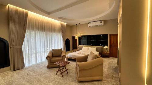 a hotel room with a bed and a couch and chairs at Aryaf hostel in Nizwa
