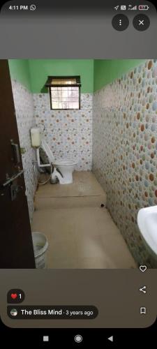 a bathroom with a toilet and a sink and a window at The Bliss Mind in Almora