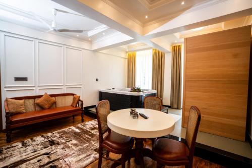 a living room with a table and chairs and a couch at Hotel C7 Munnar in Munnar