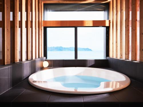 a large bath tub in a room with a window at CAP MARTIN Funny house - Vacation STAY 68833v in Minamiboso