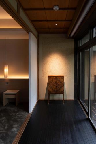 a bench sitting in a room with a window at Momoyama Onsen Tsukimikan in Kyoto