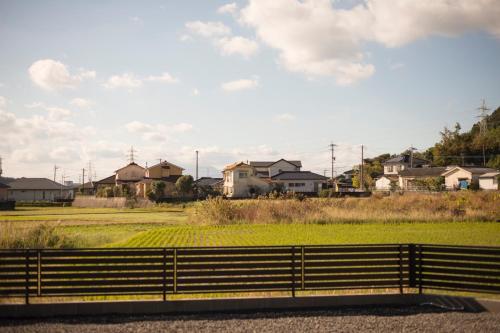 a fence in front of a field with houses at HanareSou - Vacation STAY 15441 in Kirishima