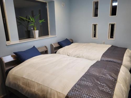 a bedroom with two beds and a window at Seaside Garage Shima - Vacation STAY 77073v in Shima