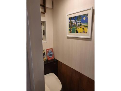 a bathroom with a toilet and a picture on the wall at Seaside Garage Shima - Vacation STAY 77073v in Shima