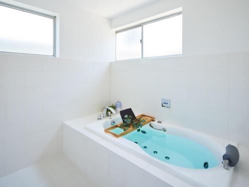 a bath tub in a white bathroom with two windows at SAJIMA Funny house - Vacation STAY 15436 in Hayama