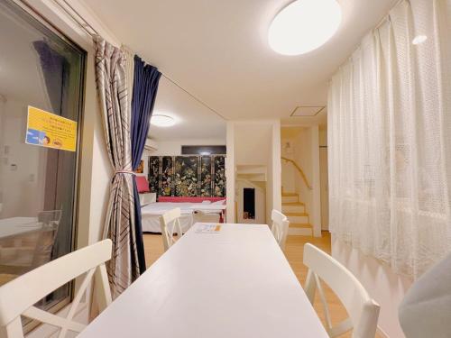 ein Esszimmer mit einem weißen Tisch und Stühlen in der Unterkunft JINGHOUSE Takasago detached house - Vacation STAY 17050 in Tokio