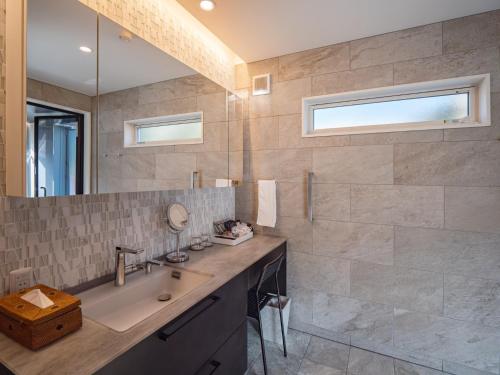 a bathroom with a sink and a mirror at MIYAZAKI BASE in aoshima - Vacation STAY 82721v in Miyazaki