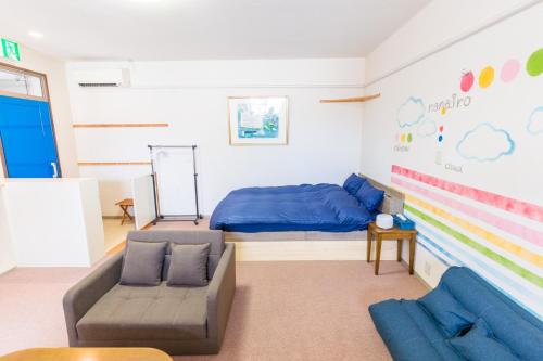 a living room with a bed and a couch at GUEST HOUSE BLUE DOORS - Vacation STAY 73130v in Yamagata