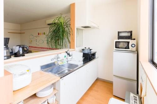 a kitchen with a sink and a refrigerator at GUEST HOUSE BLUE DOORS - Vacation STAY 73130v in Yamagata