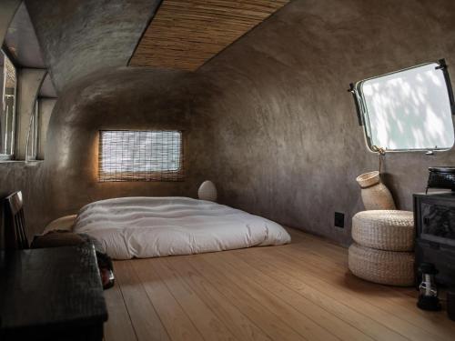 a bedroom with a bed in the corner of a room at Lost Cabin - Vacation STAY 89724v in Kamogawa