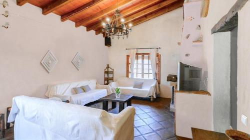 a living room with white furniture and a chandelier at El Zorro Almáchar by Ruralidays in Almáchar