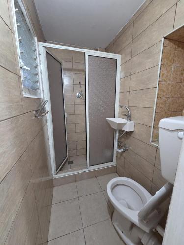 a bathroom with a shower and a toilet and a sink at Olive Guest House in Haifa
