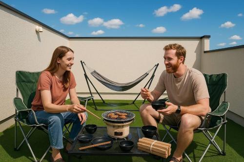 a man and a woman sitting in chairs around a table at Shinchiku design house - Vacation STAY 15468 in Ranzan
