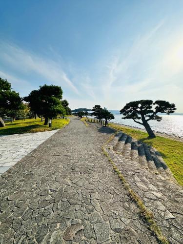 a cobblestone road next to the water with trees at Shirakata Token Residence 701 - Vacation STAY 76938v in Matsue