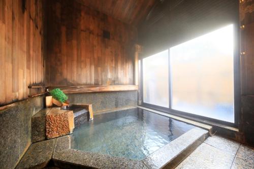 a swimming pool in a room with a window at Kaike Fuga in Yonago