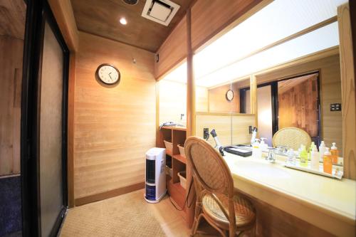 a bathroom with a sink and a clock on the wall at Kaike Fuga in Yonago