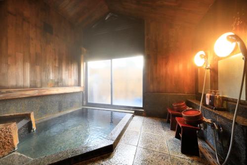 a hot tub in a room with a window at Kaike Fuga in Yonago