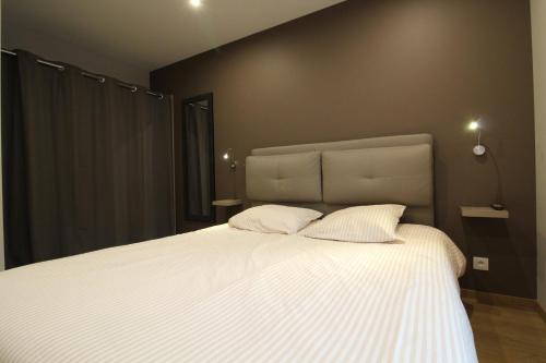 a bedroom with a large white bed with two pillows at Appartement à La Bresse, proche des lacs, pistes de ski et randonnées in La Bresse