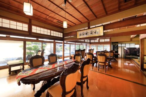 a dining room with a long table and chairs at Kaike Fuga in Yonago