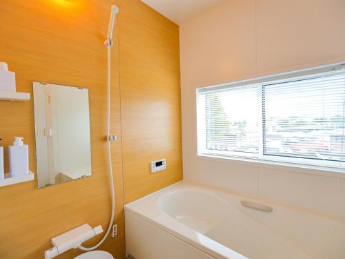 a bathroom with a tub and a toilet and a window at Asama no Iori - Vacation STAY 01001v in Fujiyoshida