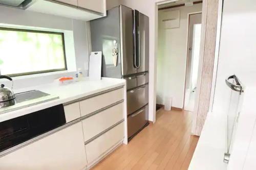 a kitchen with a stainless steel refrigerator at Itsukaichi First Villa Hiroshima - Vacation STAY 15653 in Hiroshima