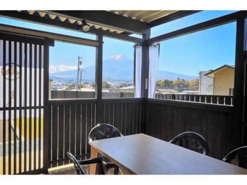 a table and chairs on a balcony with mountains at Asama no Iori - Vacation STAY 00952v in Fujiyoshida