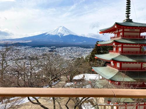 a pagoda with a snow covered mountain in the background at Asama no Iori - Vacation STAY 00952v in Fujiyoshida