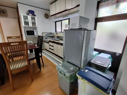 a kitchen with a refrigerator and a table and a table at Guesthouse Kirishima - Vacation STAY 02754v in Kirishima