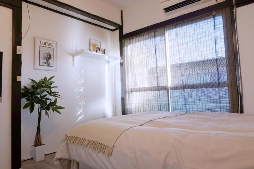 a bedroom with a bed and a large window at green park heights - Vacation STAY 15686 in Musashino