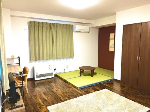 ein Wohnzimmer mit einem Tisch und ein Zimmer mit Matten in der Unterkunft Hakodatekan - Vacation STAY 07879v in Hakodate