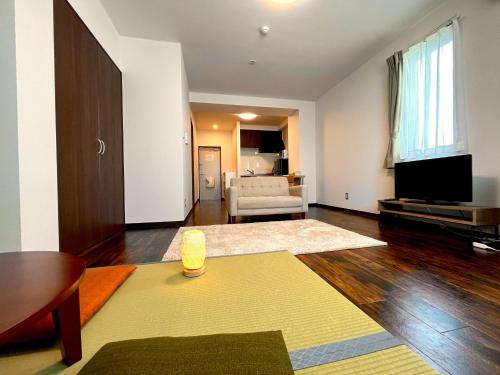 a living room with a couch and a television at Hakodatekan - Vacation STAY 07879v in Hakodate