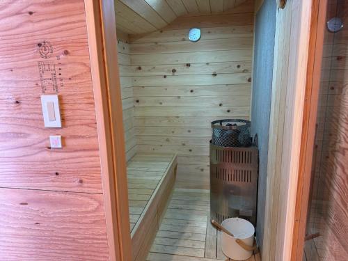 a sauna with a wood paneled wall and a wooden floor at ARTISAN tomioka - Vacation STAY 84893v in Tomioka