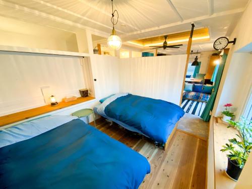 a bedroom with two blue beds and a window at Kojohama base - Vacation STAY 89929v in Shikyū