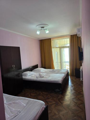 a hotel room with two beds and a window at Sunny Beach Hotel in K'obulet'i