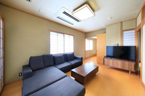 a living room with a couch and a flat screen tv at Kaike Fuga in Yonago