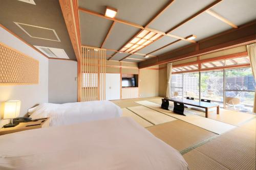 a bedroom with two beds and a large window at Kaike Fuga in Yonago