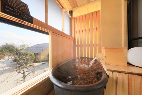 a bath tub in a room with a window at Kaike Fuga in Yonago