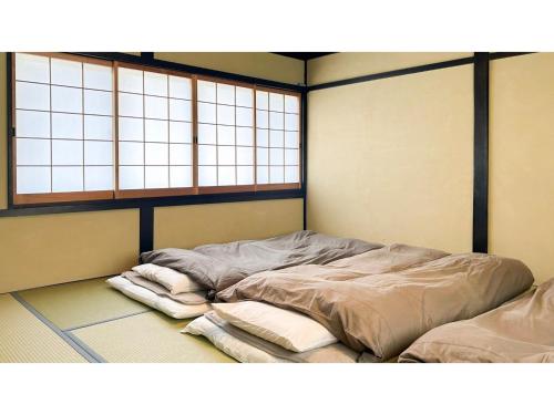 亀岡市にあるKoiya - Vacation STAY 04646vの窓2つが備わる客室で、ベッドメイキングは行っていません。