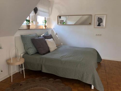 a bedroom with a bed with pillows and a mirror at Ferienwohnung Eifelglück in Pelm