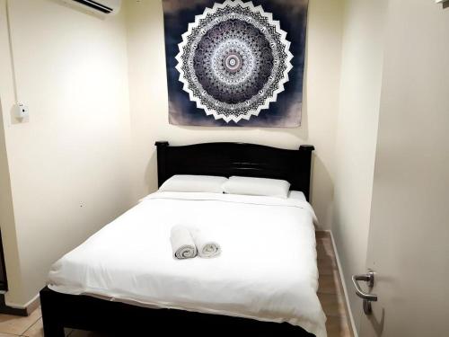 a bedroom with a white bed with two towels on it at De Chukai Hotel in Cukai